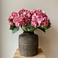 Load image into Gallery viewer, Field &amp; Rose pink artificial hydrangea stem, 53cm, silk flower with green leaves in a rustic vase.
